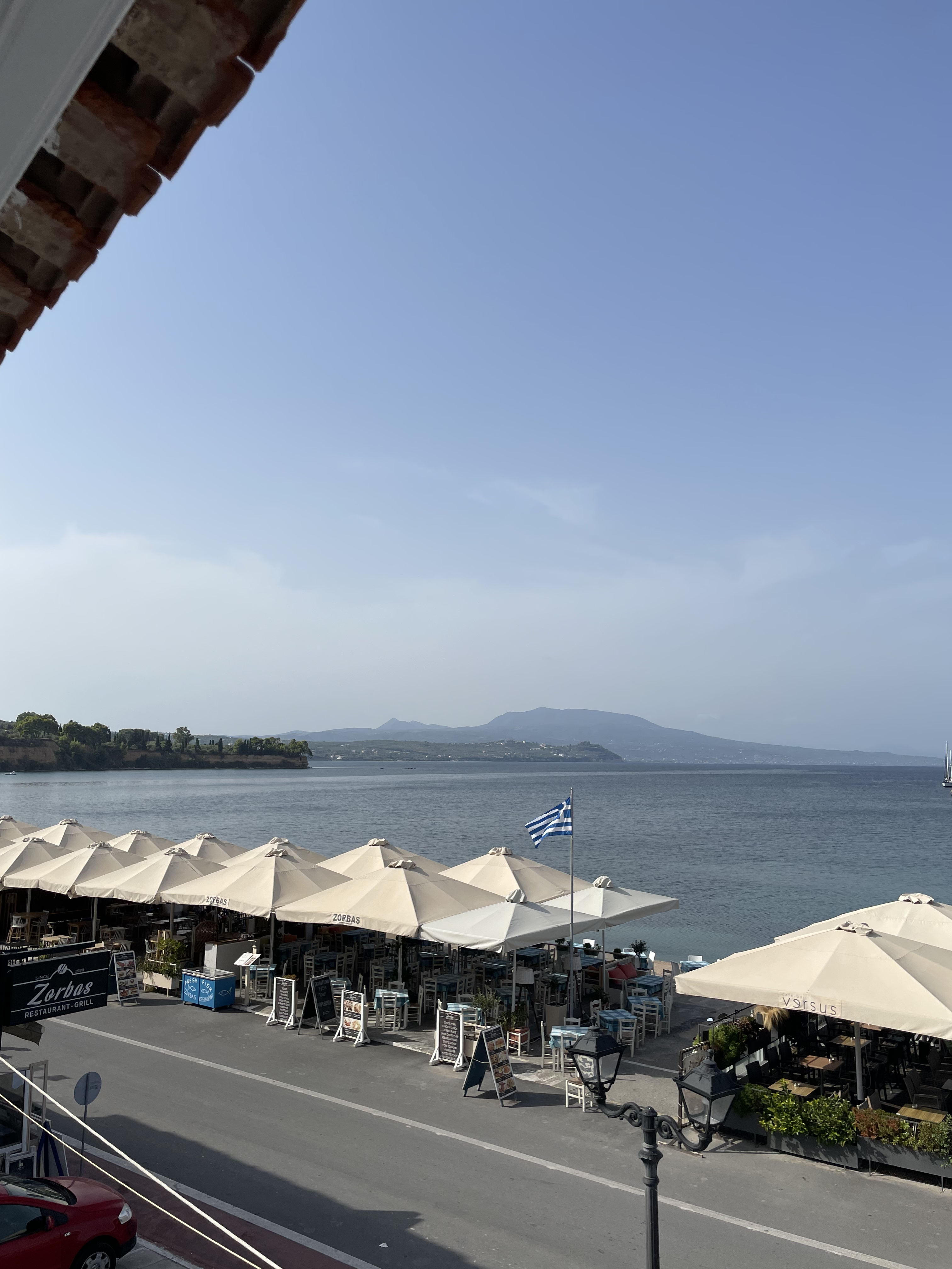 Wide harbour panorama with Greek flag and restaurants
