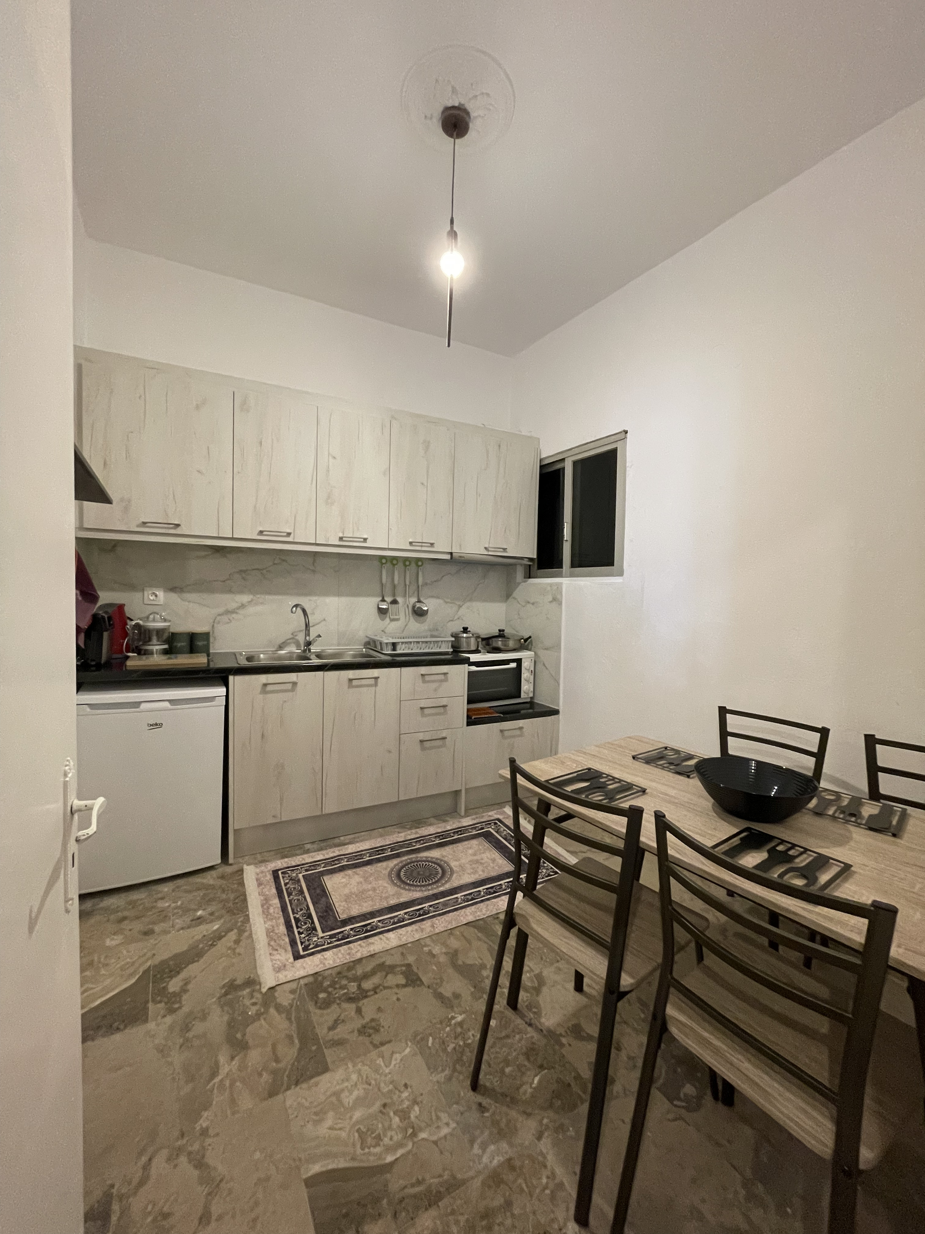 Kitchen with white marble cabinets and dining area