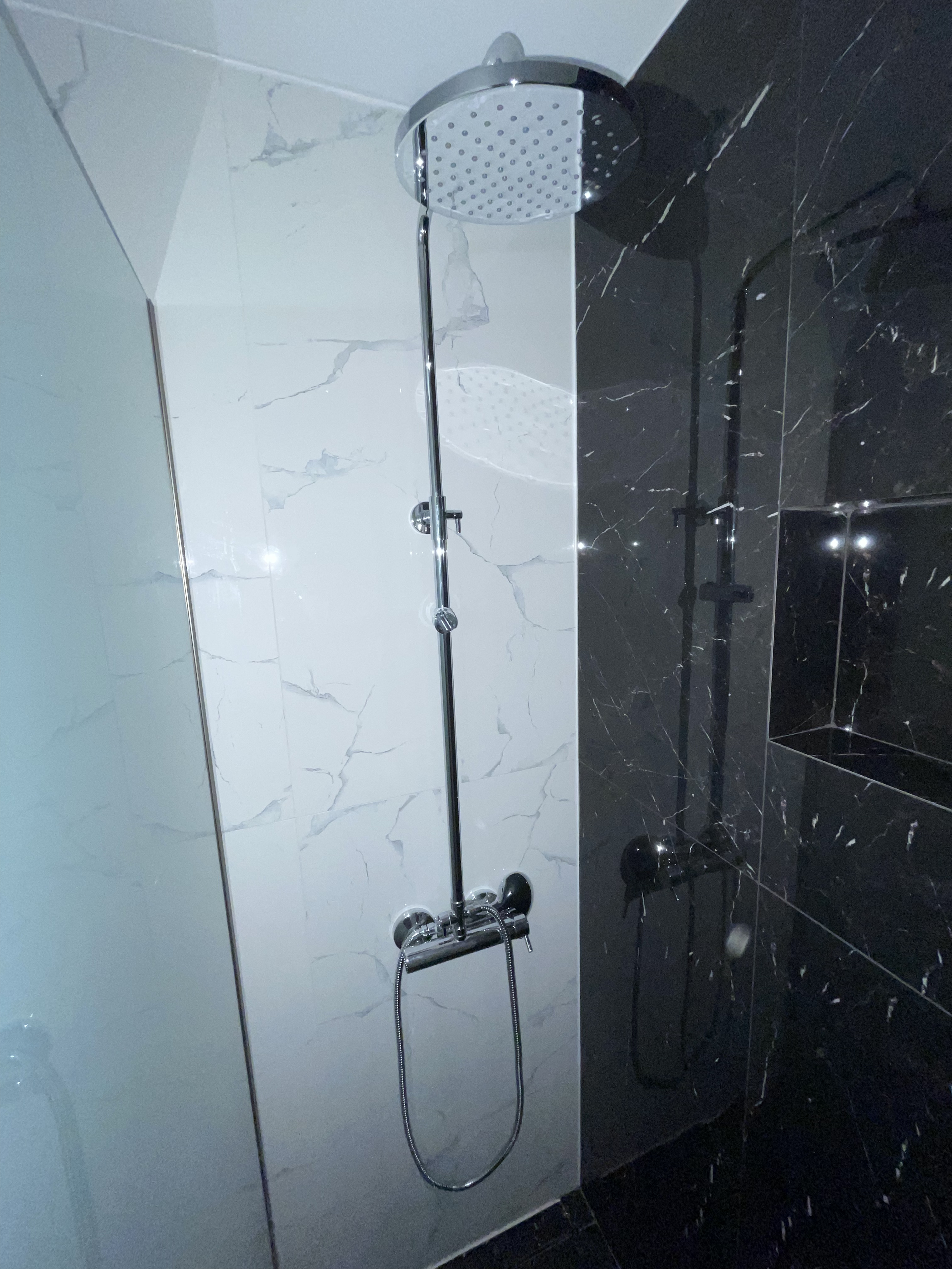 Modern rain shower with black marble tiles