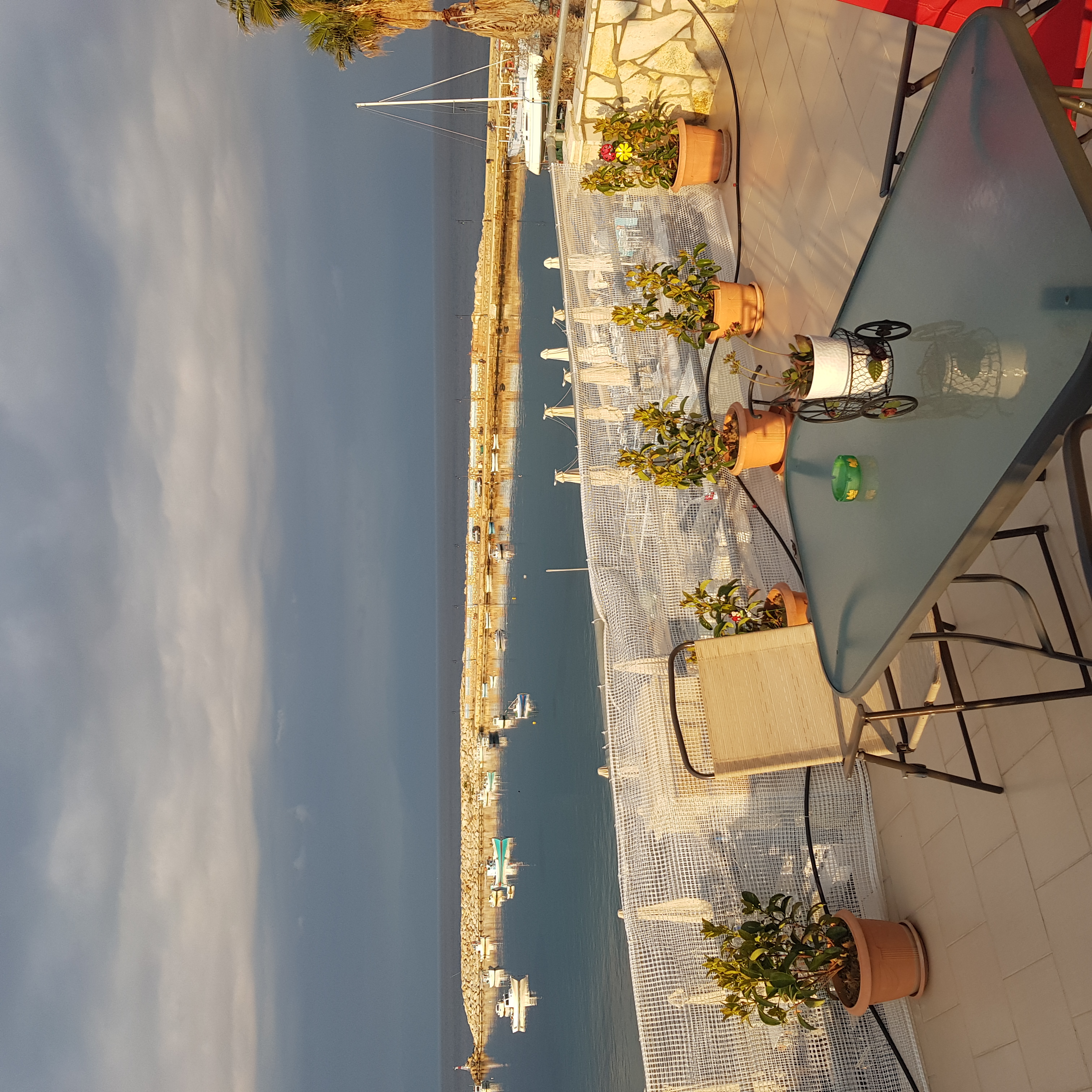 Terrace table at golden hour with harbour and sea view