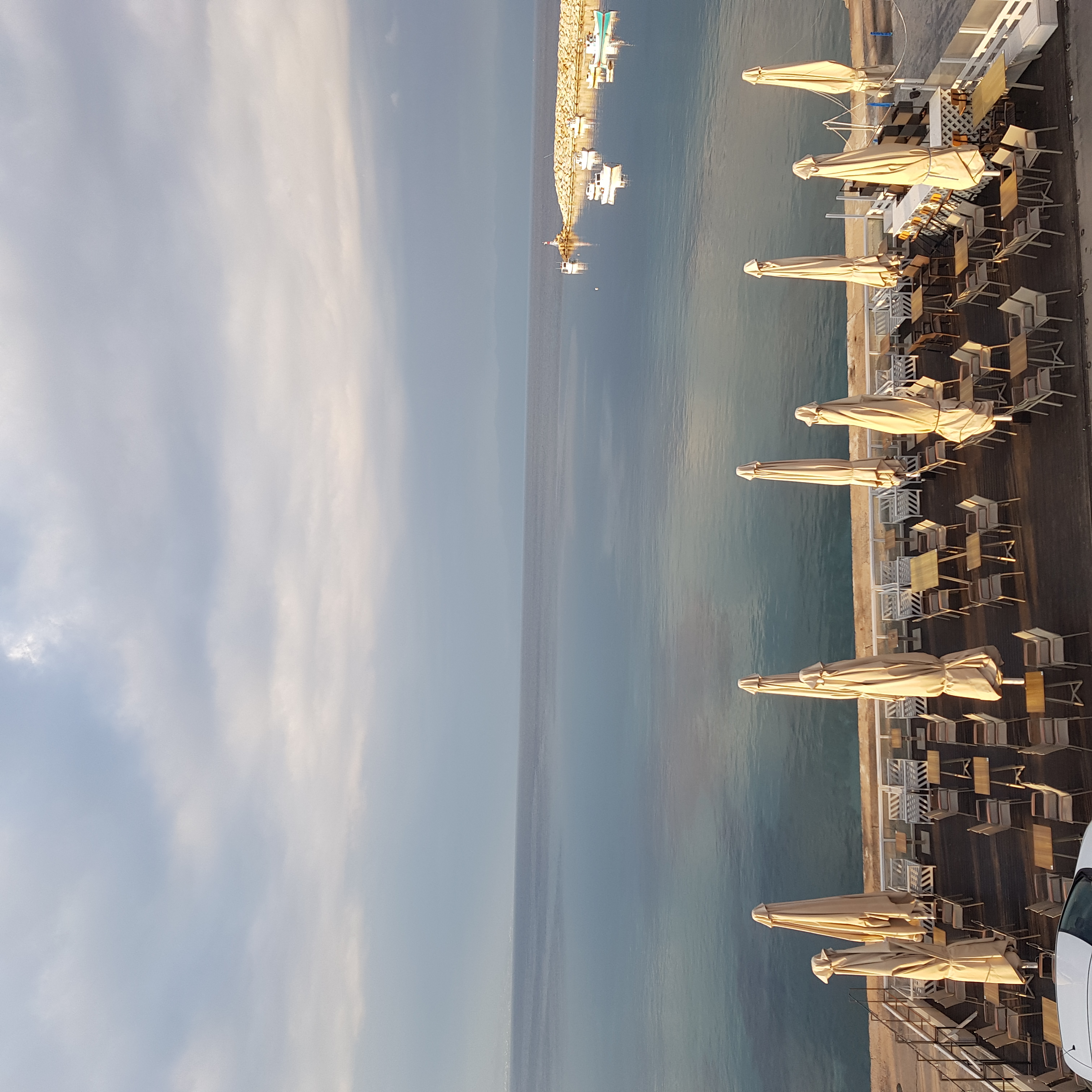 Sea and harbour from above with beach umbrellas
