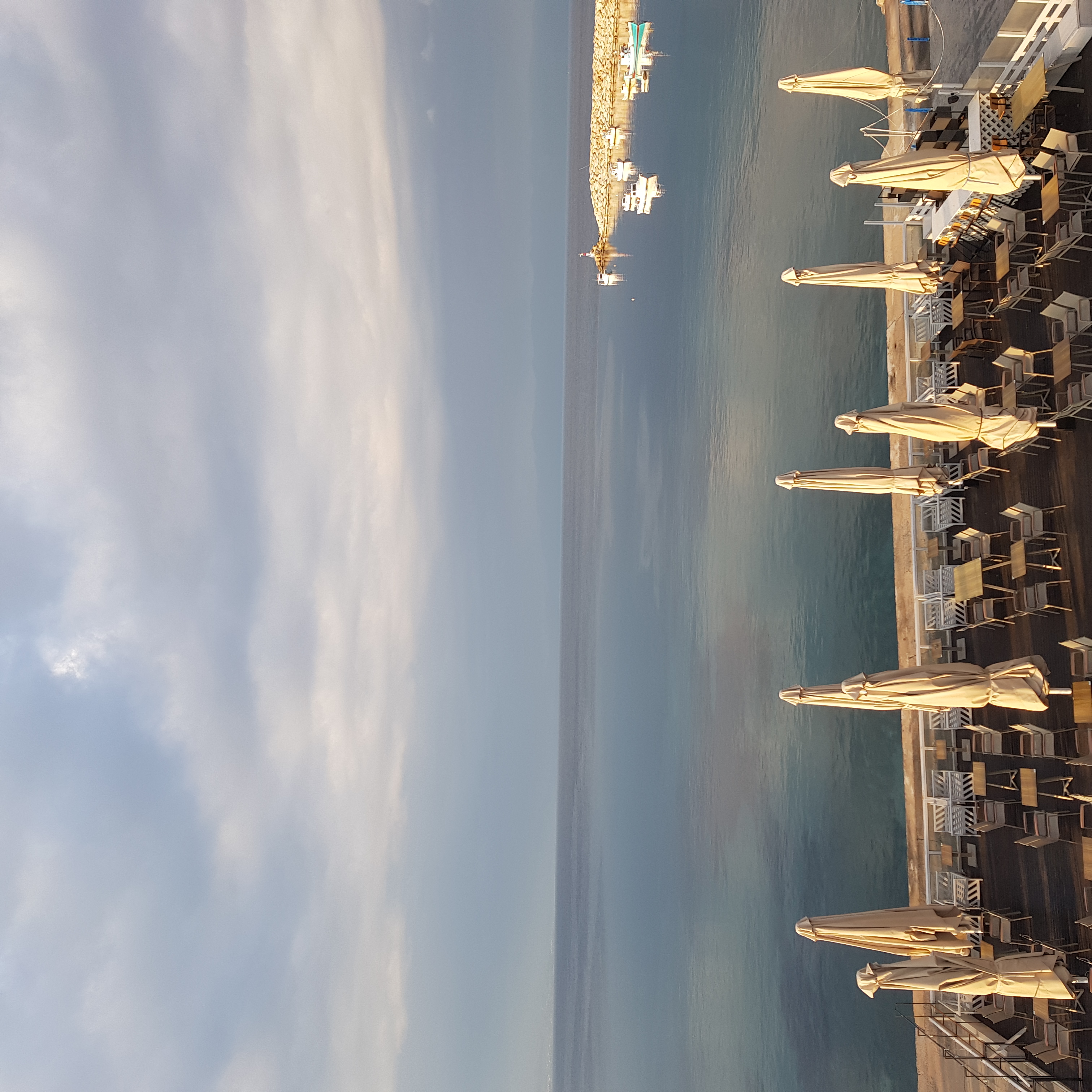 Harbour view with cafe umbrellas at golden hour