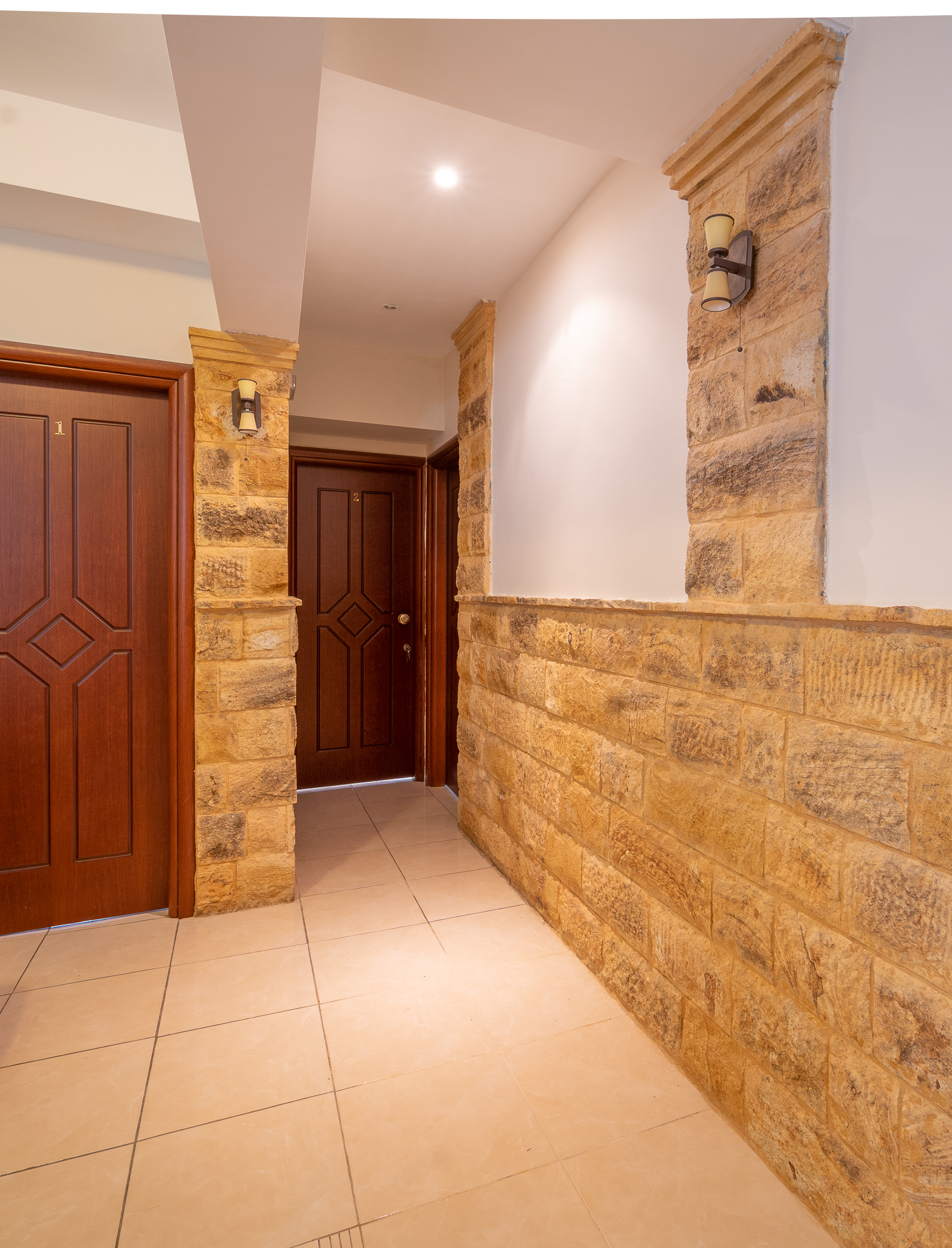 Stone-walled corridor with room doors