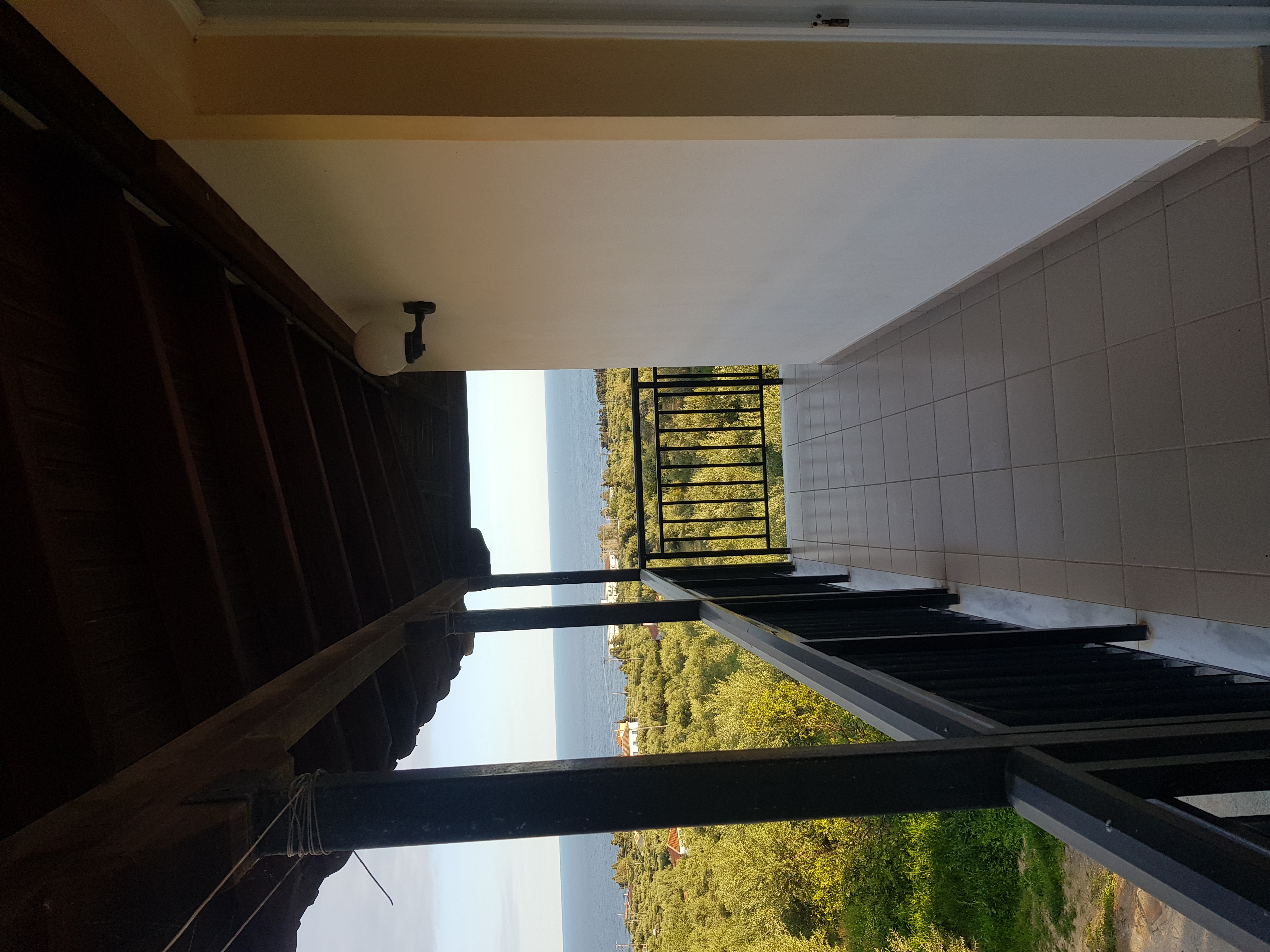 Long veranda with olive grove and sea glimpse beyond