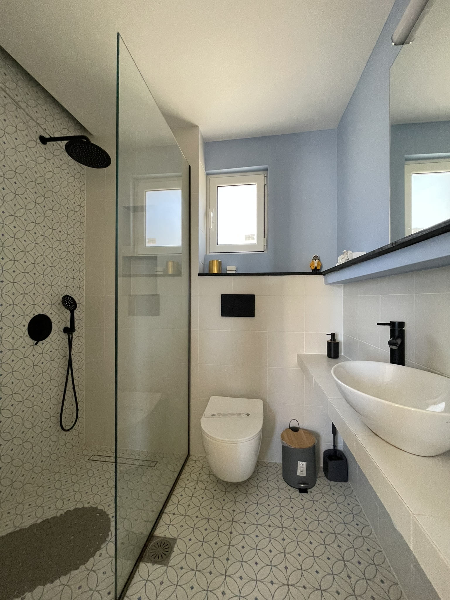 Modern bathroom with rain shower and patterned tiles