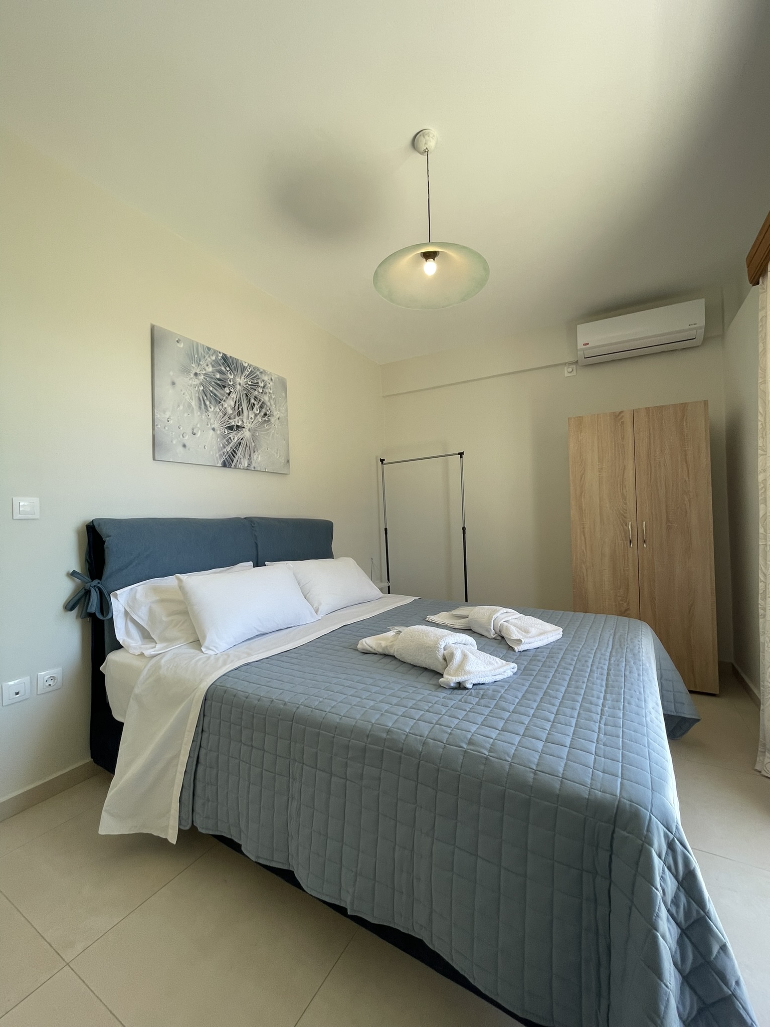Double bedroom with blue headboard and pendant light